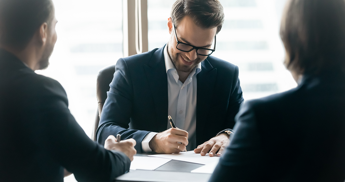 Conoce el ABC de la Póliza de Disposiciones Legales | Nacional de Seguros persona firmando hoja de disposiciones Legales